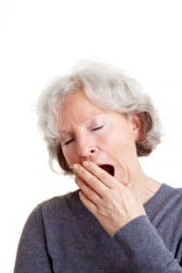 A woman covering her mouth while yawning