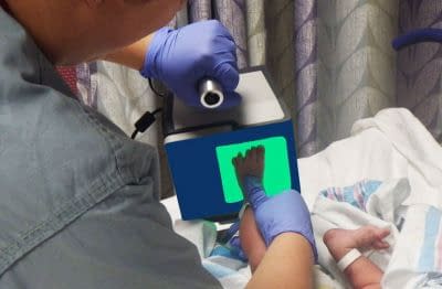 baby getting their footprint scanned with a digital footprint scanner